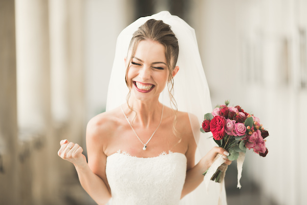 Luxury wedding bride, girl posing and smiling with bouquet.